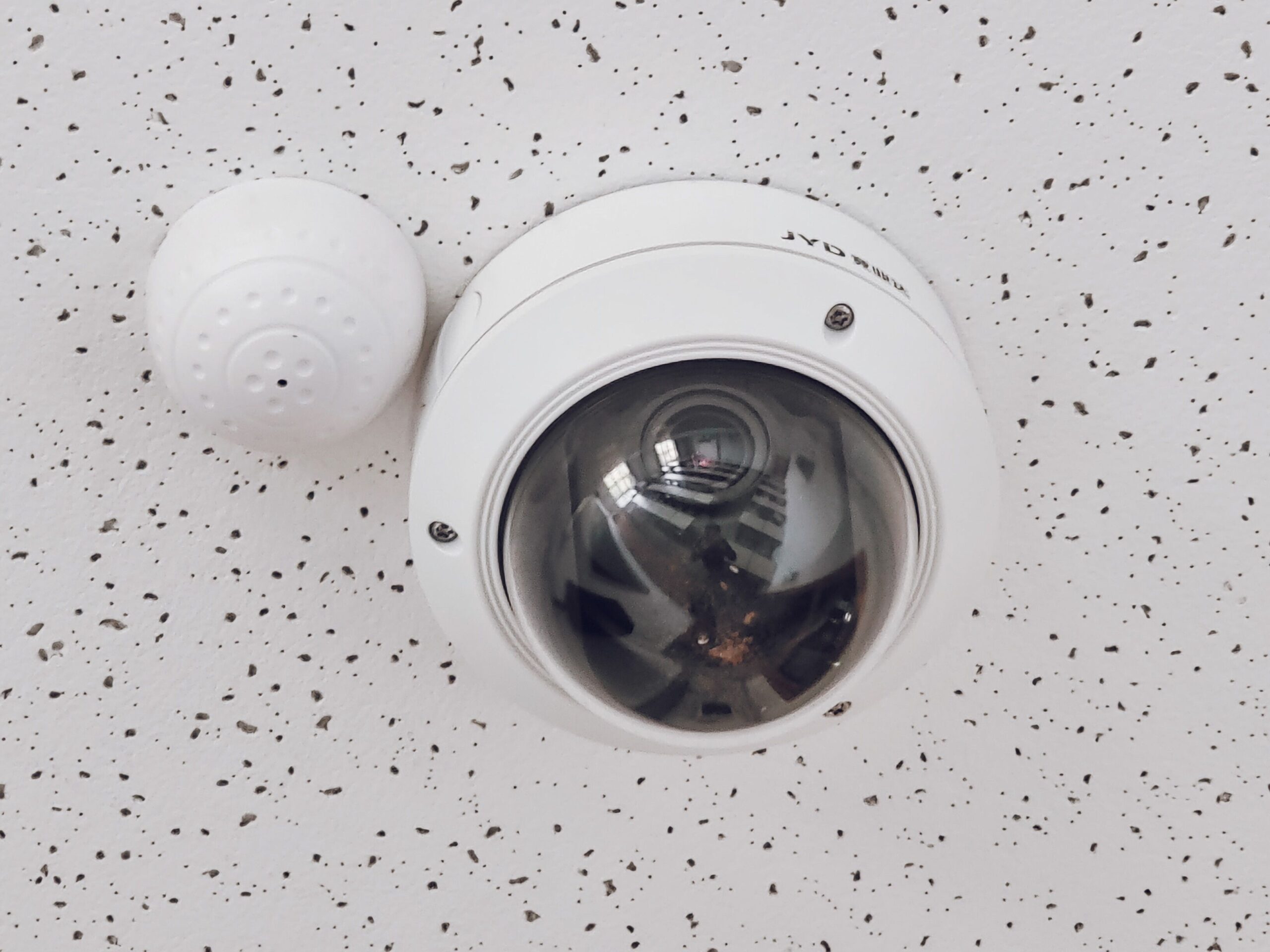 White ceiling-mounted security camera
